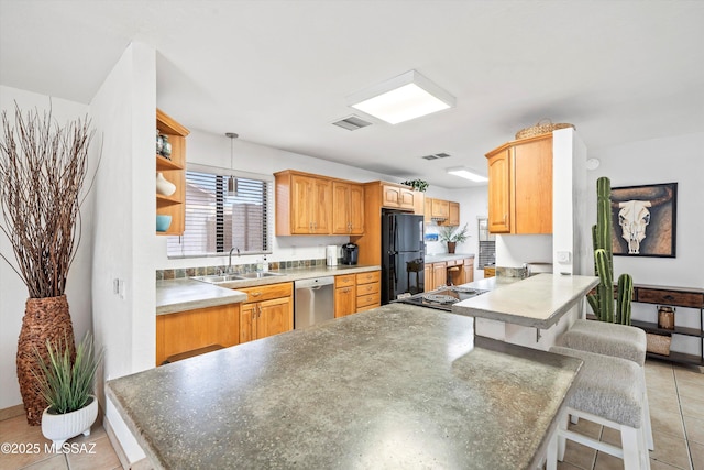 kitchen with a breakfast bar area, freestanding refrigerator, a sink, dishwasher, and a peninsula