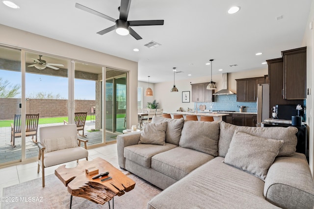 living area with light tile patterned floors, a ceiling fan, visible vents, and recessed lighting