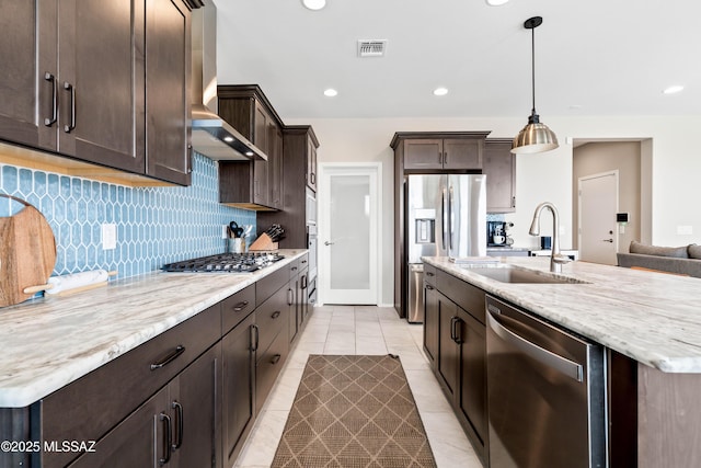 kitchen with dark brown cabinetry, appliances with stainless steel finishes, backsplash, and a sink