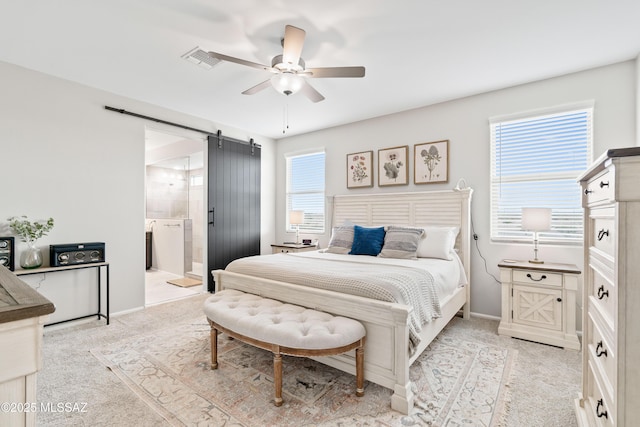 bedroom with light colored carpet, visible vents, a barn door, a ceiling fan, and baseboards