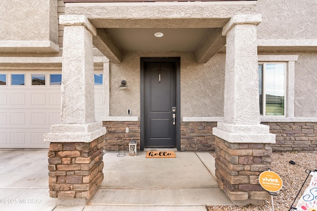 view of exterior entry featuring stone siding and stucco siding