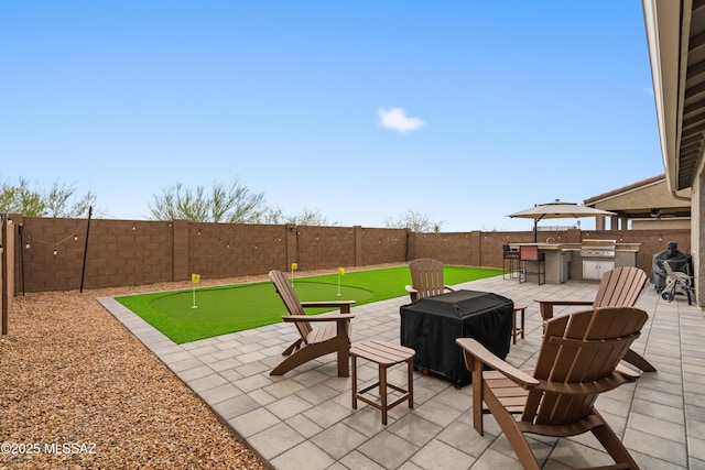 view of patio featuring an outdoor kitchen, a fenced backyard, and a grill