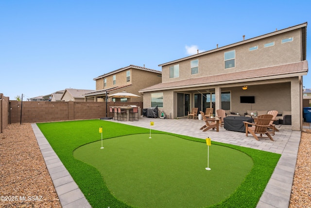 back of house with a patio area, an outdoor fire pit, outdoor dry bar, and stucco siding