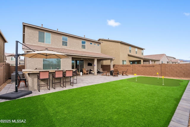 back of house featuring an outdoor fire pit, a patio, a fenced backyard, outdoor dry bar, and stucco siding