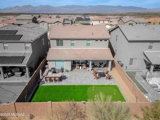 back of house with a tiled roof, outdoor lounge area, a fenced backyard, and a residential view