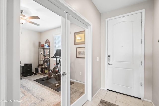 entryway featuring baseboards and a ceiling fan