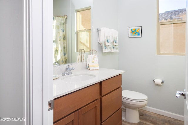 full bathroom featuring toilet, baseboards, wood finished floors, and vanity