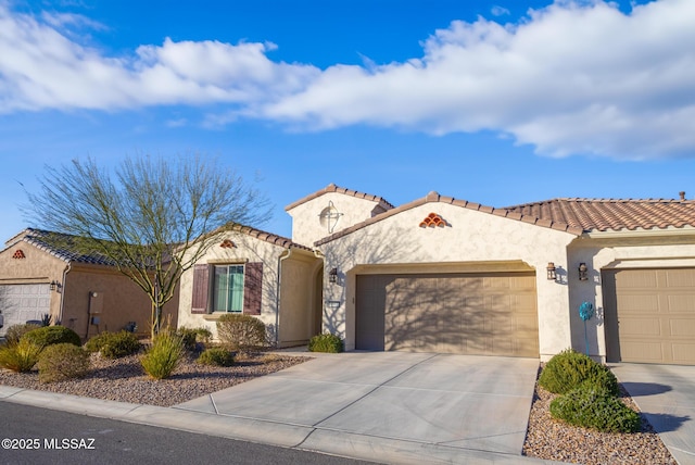 view of front of property featuring concrete driveway, an attached garage, a tile roof, and stucco siding