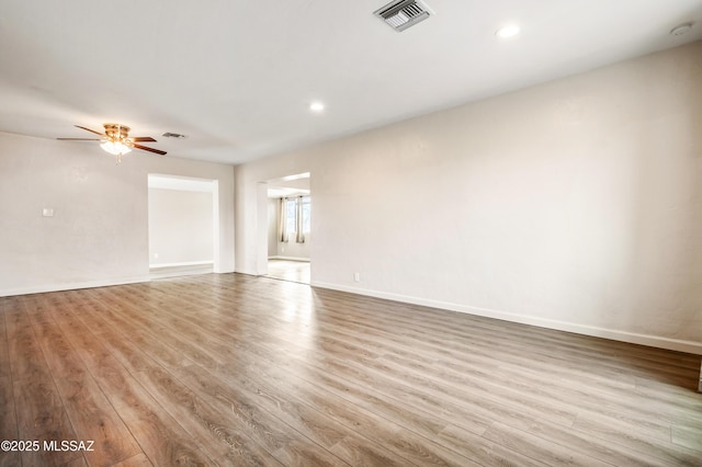 unfurnished living room with visible vents, baseboards, and wood finished floors