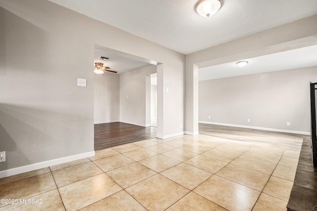 unfurnished room featuring light tile patterned floors, baseboards, and a ceiling fan