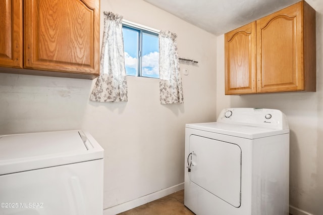 laundry room with independent washer and dryer, cabinet space, and baseboards