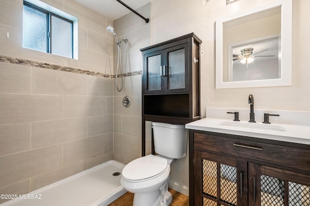 bathroom with tiled shower, vanity, and toilet