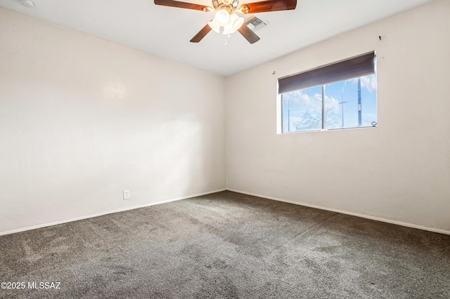 spare room featuring carpet floors, visible vents, ceiling fan, and baseboards