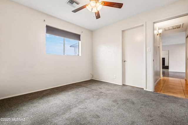 unfurnished bedroom with baseboards, carpet, visible vents, and a ceiling fan