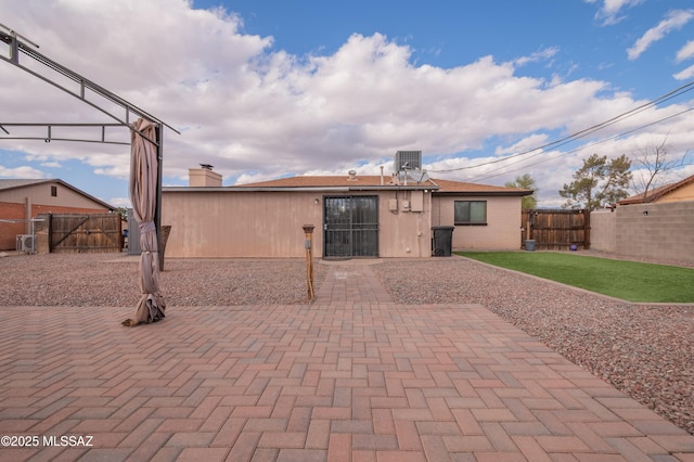 back of property with a patio area, a fenced backyard, a lawn, and central air condition unit