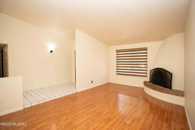 unfurnished living room with a fireplace and wood finished floors