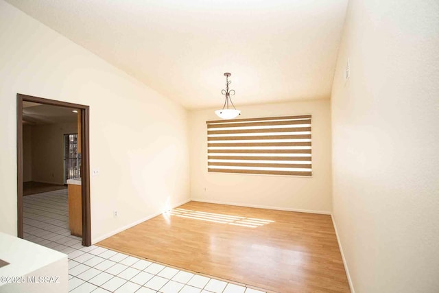 spare room featuring light wood finished floors and baseboards