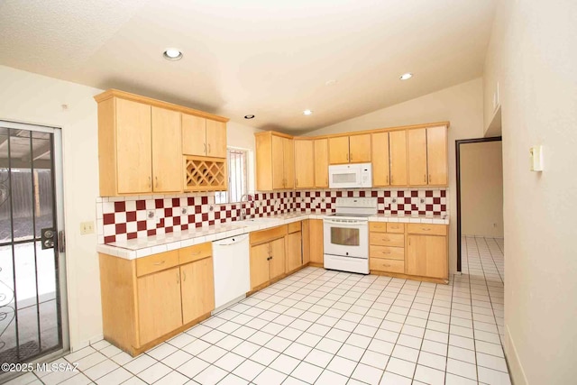 kitchen featuring tile counters, white appliances, light brown cabinets, and a sink