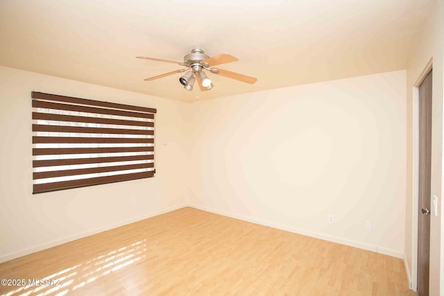 unfurnished room with a ceiling fan, baseboards, and wood finished floors