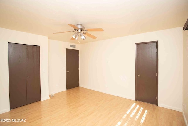 unfurnished bedroom featuring ceiling fan, light wood finished floors, and visible vents