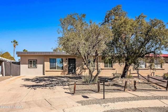 ranch-style home with brick siding and fence