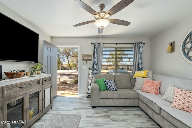 living room featuring light wood-type flooring and a ceiling fan