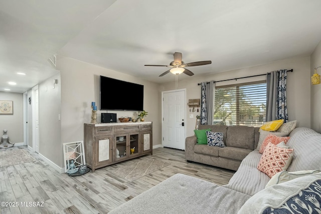 living area with ceiling fan, baseboards, and wood finished floors