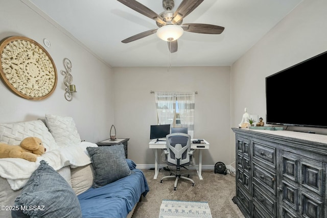 carpeted office space with ceiling fan and baseboards