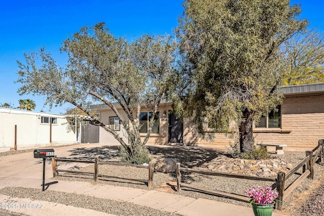 view of front of property with a fenced front yard and brick siding