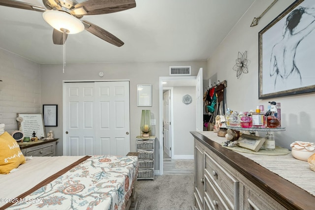 bedroom with ceiling fan, a closet, visible vents, and light colored carpet