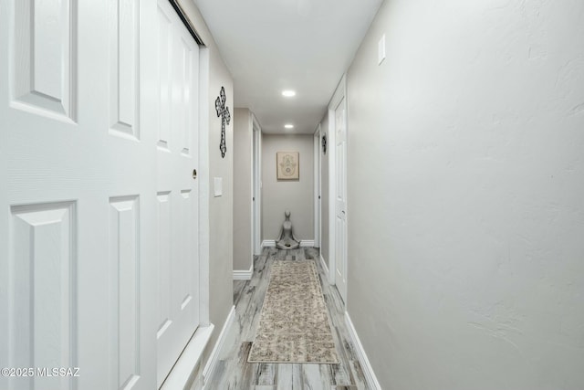 corridor with recessed lighting, light wood-style flooring, and baseboards