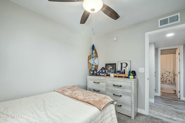 bedroom with ceiling fan, baseboards, visible vents, and light colored carpet