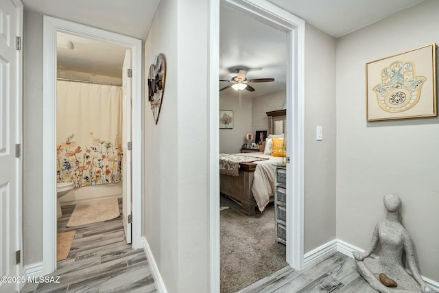 corridor with baseboards and wood finished floors