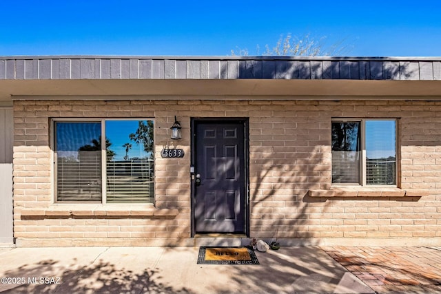 doorway to property with brick siding