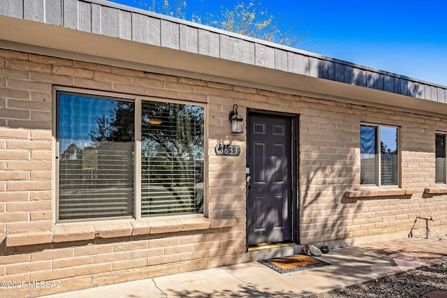 property entrance featuring brick siding