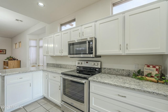 kitchen with a healthy amount of sunlight, white cabinetry, and appliances with stainless steel finishes