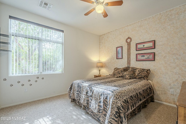 bedroom featuring ceiling fan, visible vents, baseboards, carpet, and wallpapered walls