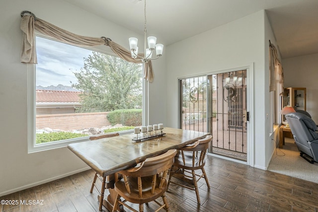 dining area featuring dark wood-style floors, baseboards, and a notable chandelier