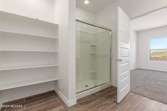 full bath with a stall shower, wood tiled floor, baseboards, and recessed lighting