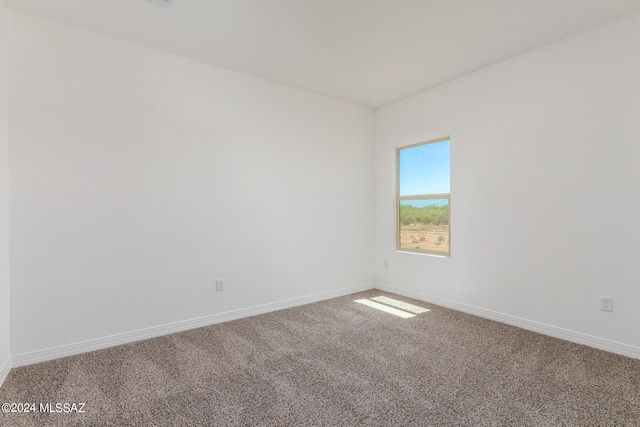 unfurnished room with carpet floors and baseboards