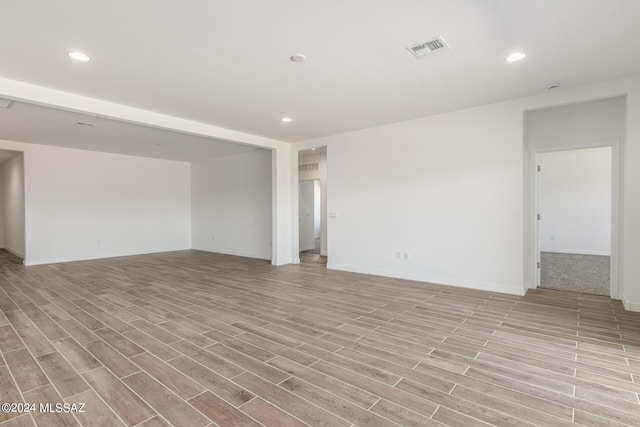 empty room with light wood-type flooring, recessed lighting, visible vents, and baseboards