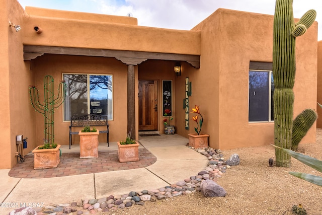 entrance to property featuring stucco siding