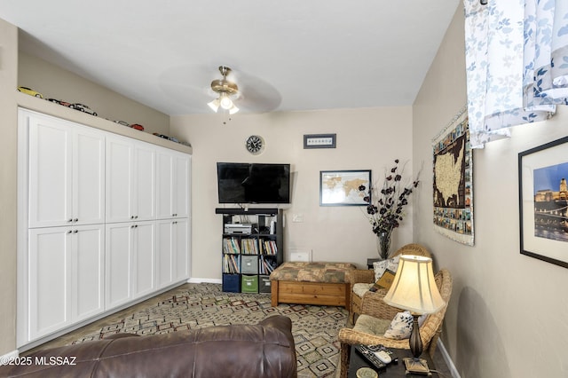 living room with baseboards and ceiling fan