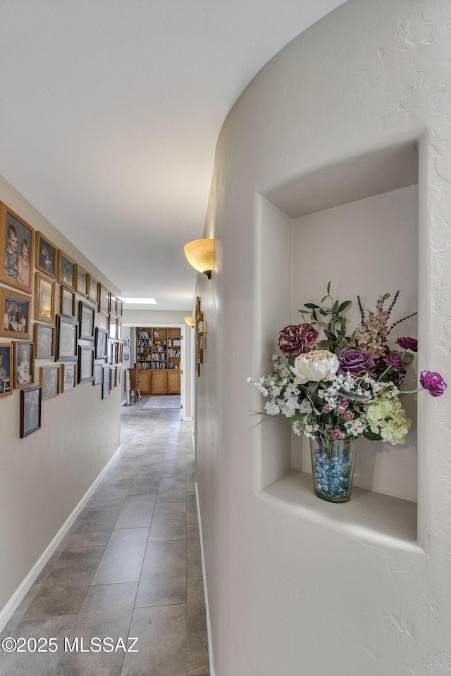 corridor with tile patterned flooring and baseboards