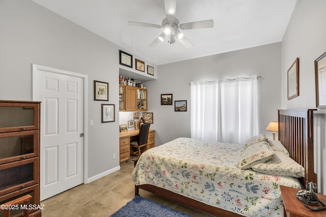 bedroom featuring baseboards, a ceiling fan, and built in study area