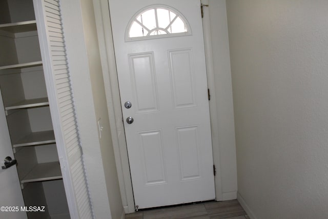 doorway with baseboards and wood finished floors