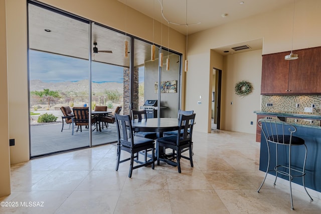 dining room with a mountain view, light tile patterned flooring, visible vents, and ceiling fan