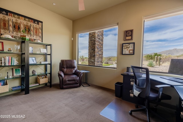 carpeted home office featuring a ceiling fan