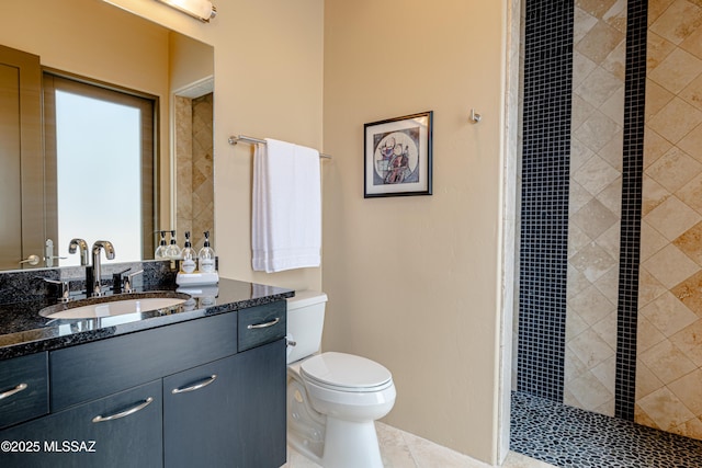 bathroom with tile patterned floors, tiled shower, toilet, and vanity