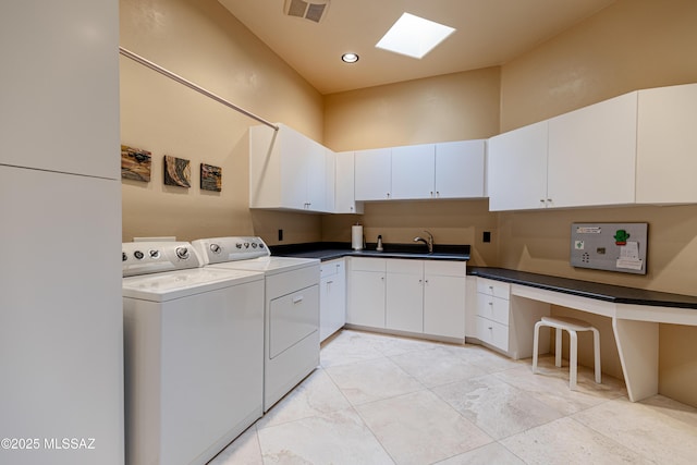 washroom with visible vents, a high ceiling, a skylight, cabinet space, and independent washer and dryer